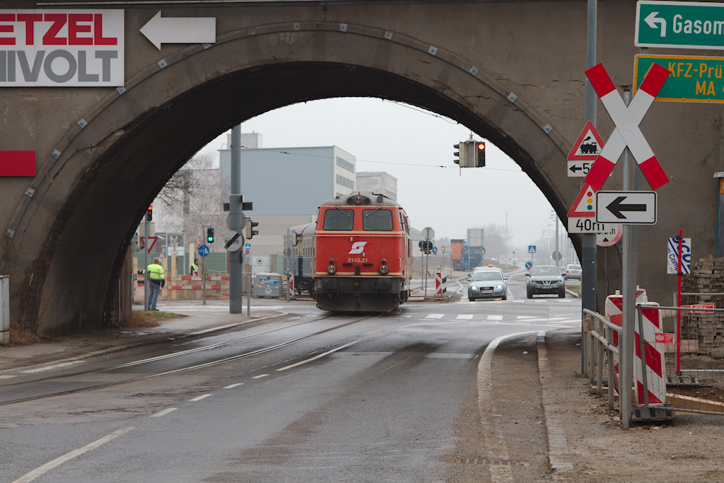Die 2143.21 fhrt gerade von den Anschlussgleisen des Kraftwerks Simmering kommend durch einen Durchlass unter der Ostbahn. Man beachte die fr sterreich ungewhnliche Ausfhrung des Andreaskreuz am rechten Bildrand. (30.03.2013)