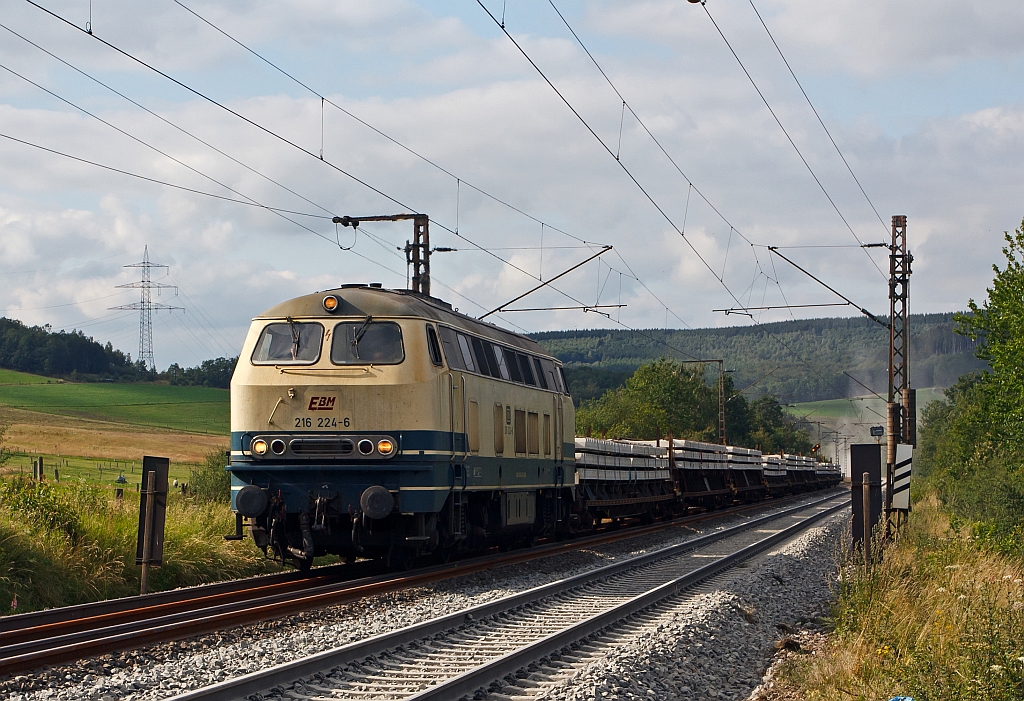 Die 216 224-6 der EBM Cargo (Gummersbach) kommt mit einem Schwellenzug am 29.07.2011 von Siegen �ber das Baugleis in Wilnsdorf-Rudersdorf (KBS 445). Die Lok wurde 1968 bei Krupp unter der Fabriknummer 4885 gebaut. Hinten den Staub wirbelt eine Schotterplaniermschine auf.