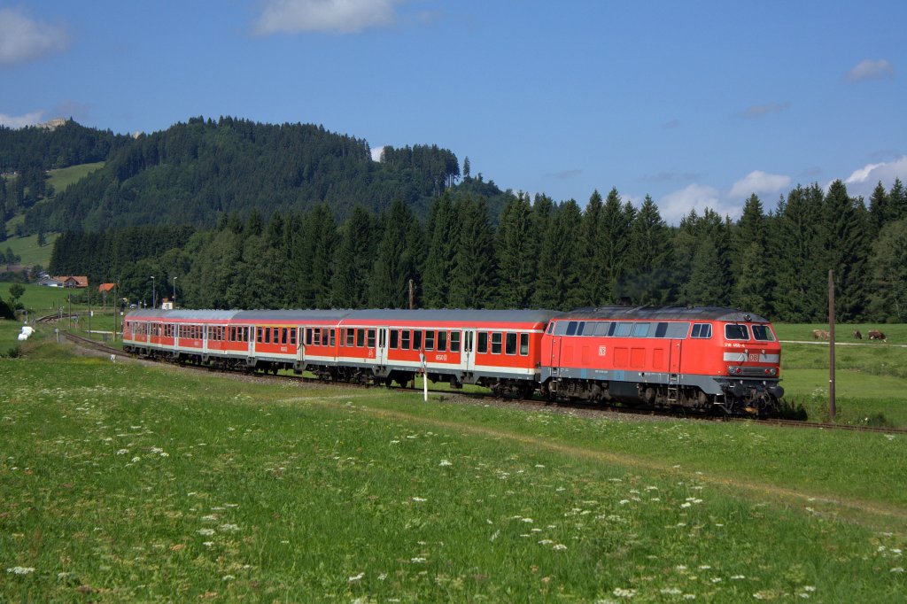 Die 218 460-4 schiebt am 08.08.2012 ihren RE durch Weizern-Hopferau.