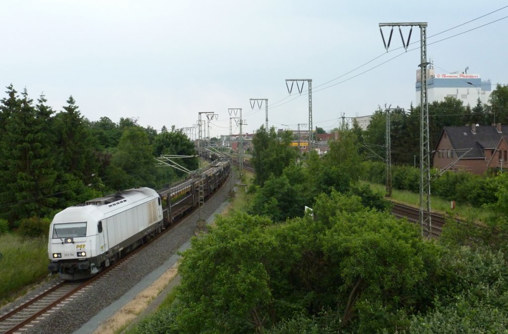 Die 223 154 fuhr am 11.06.2012 mit einem Autozug von Emden gen Osten, hier in Leer.