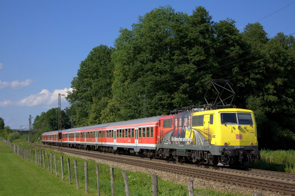 Die ADAC 111 024-6 schiebt am 10.07.2012 einen RE von Salzburg nach Mnchen durch Vogl bei Grokarolinenfeld.