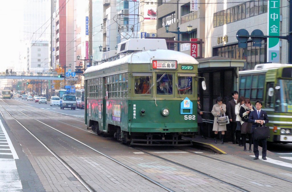 Die ältesten Strassenbahnwagen von Hiroshima: Das Strassenbahnnetz von Hiroshima (1435mm-Spur) umfasst 8 Linien, ingesamt 19 km Stadt- und 16,1 km Ueberlandstrecken. Während vielen Jahren wurden Wagen aus Städten übernommen, deren Strecken eingestellt wurden, etwa auch aus Kôbe. Kôbe verlor sein Strassenbahnnetz 1971, und so gelangten die grossen erneuerten Wagen (urspr. 1924 gebaut) als Serie 571-587 nach Hiroshima. Im Bild Wagen 582 in der Stadtmitte von Hiroshima (Hondoori), 6.Dezember 2010.  