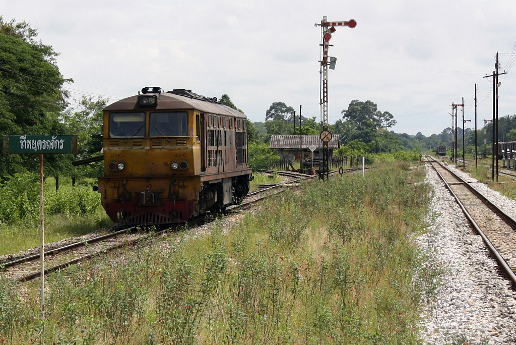 Die AHK 4210 (Co'Co', de, Krupp, Bj.1980, Fab.Nr. K-5479) umfährt am 27.Oktober 2010 in der Khao Chum Thong Junction den ORD 455 (Nakhon Si Thammarat - Yala). Rechts im Bild das Gleis in Richtung Hat Yai, hinter der Lok erkennt man die Abzweigung nach Nakhon Si Thammarat.

