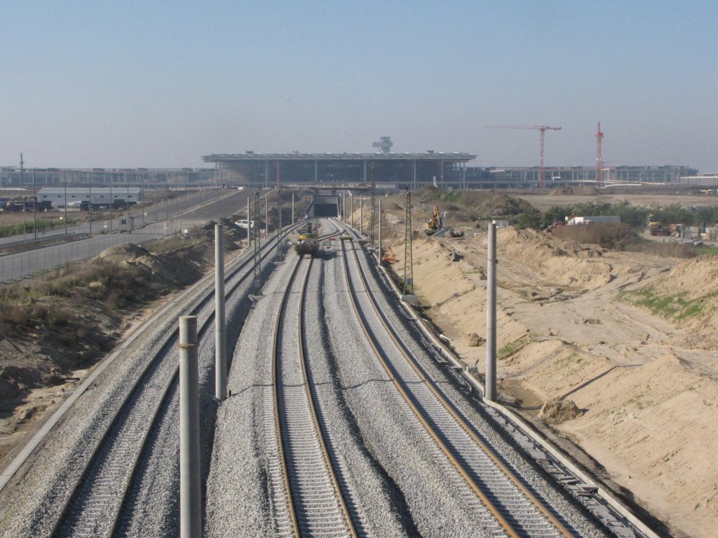 Die Bauarbeiten f�r die Ostanbindung zum BBI  Willy Brandt  laufen auf hochtour.hier zu sehen links und rechts die Streckengleise nach Bohnsdorf West in der Mitte das Ausziehgleis zum Abstellen bzw. Bahnsteigwechsel der RE.Im Hintergrund das neue Flughafengeb�ude.