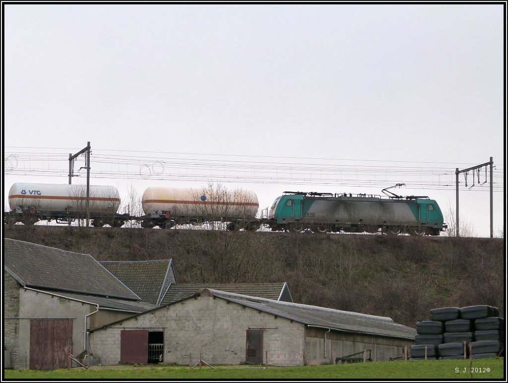Die belgische Traxx 2828 (Cobra)mit einen G�terzug im Schlepptau kurz vor der Durchfahrt in Montzen.Aufgenommen unweit von Moresnet in Belgien, M�rz 2012.