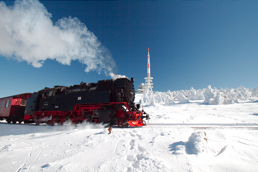 Die bergauffahrende 99.236 vor dem markanten Sender des Brocken. (04.03.2013)