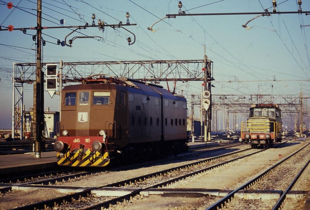 Die braune FS Elektrolok 645105 wartet in der Einfahrt zum Bahnhof
Venedig Santa Lucia am 19.1.1991.