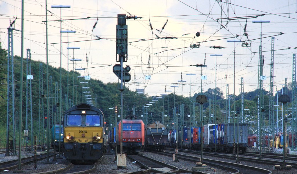 Die Class 66 DE6302 von DLC Railways steht in Aachen-West  mit einem Containerzug und wartet auf die Abfahrt nach Belgien bei Regenwolken am 27.9.2012.