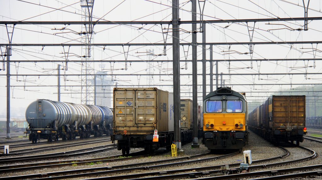 Die Class 66 DE6309 von DLC Railways steht in Montzen-Gare(B) mit einem sehr langen Containerzug bei Nieselregen am 6.5.2012.