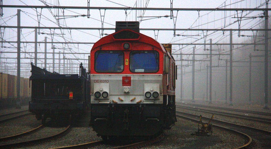 Die Class 66 DE6310  Griet  von Crossrail steht in Montzen-Gare(B) mit einem sehr langen MSC-Containerzug im Nebel am 6.1.2013.