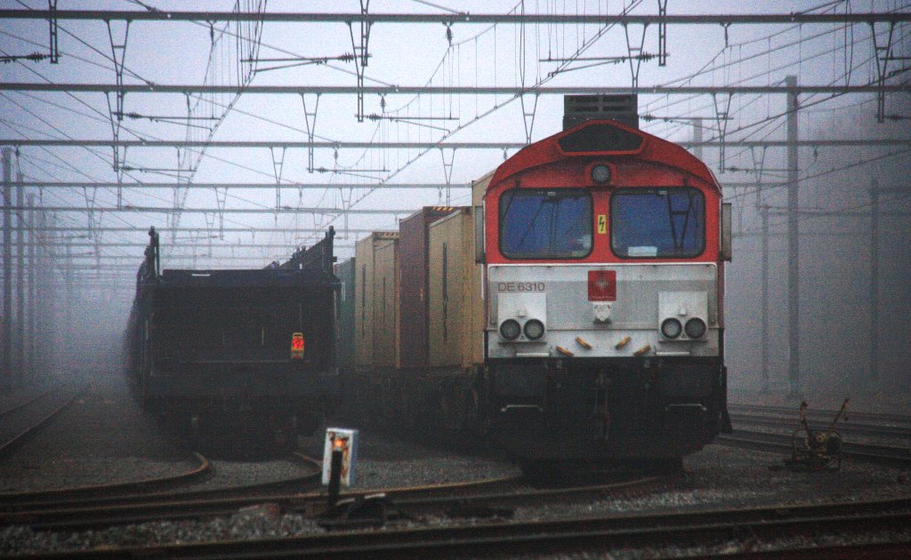 Die Class 66 DE6310  Griet  von Crossrail steht in Montzen-Gare(B) mit einem sehr langen MSC-Containerzug und wartet auf die Abfahrt nach Vise(B) bei Nebel am 6.1.2013.