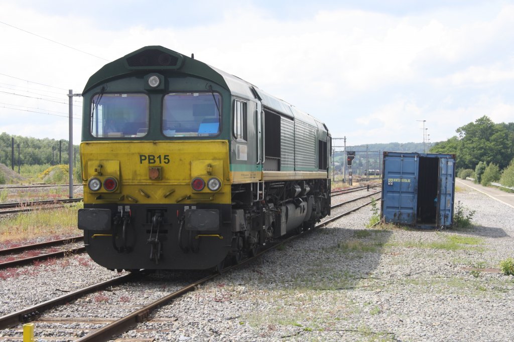 Die Class 66 PB15 von Ascendos Rail Lasing  rangiert in Montzen-Gare(B) bei Sonne.
11.6.2011