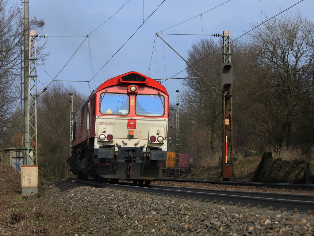 Die Class66  Federica  DE6302 von Crossrail mht sich am 22.03.2013 mit einem Containerzug auf der Rampe der Montzenroute von Aachen West nach Belgien ab. Rechts im Bild sieht man einige  Drachenzhne . Sie gehren zu Resten des Westwall, der ende der 30er Jahre des letzten Jahrhunderts von Kleve an der Niederlndischen Grenze auf eine Lge von ber 630km bis Grenzach-Wyhlen im Landkreis Lrrach an die Schweizer Grenze gebaut wurde.