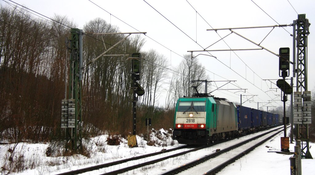 Die Cobra 2818 kommt mit einem langen Containerzug aus Richtung Montzen(B) und fhrt gleich in den Gemmenicher-Tunnel(B) rein nach Aachen-West bei Schnee und Wolken am Kalten 28.2.2.2013.