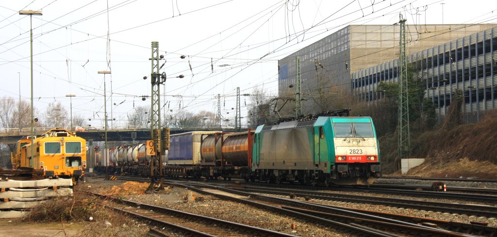 Die Cobra 2823 kommt aus Richtung Montzen/Belgien mit einem langen Containerzug aus  Antwerpen-Oorderen(B) nach Gallarate(I) und fhrt in Aachen-West ein bei Sonne und Wolken am 6.4.2013.