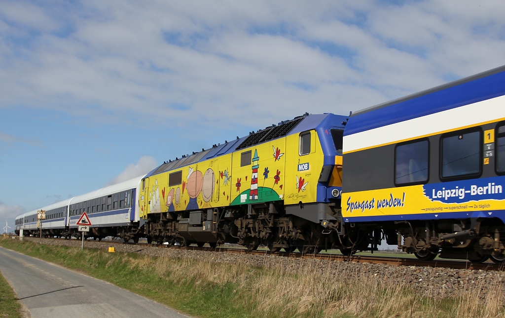 Die DE 2700-03 (251 003) zwischen zwei unterschiedlichen NOB Garnituren in Fahrtrichtung Niebll. Aufgenommen am 13.04.2012 an der Kreuzungsstelle zwischen Niebll und Klanxbll.