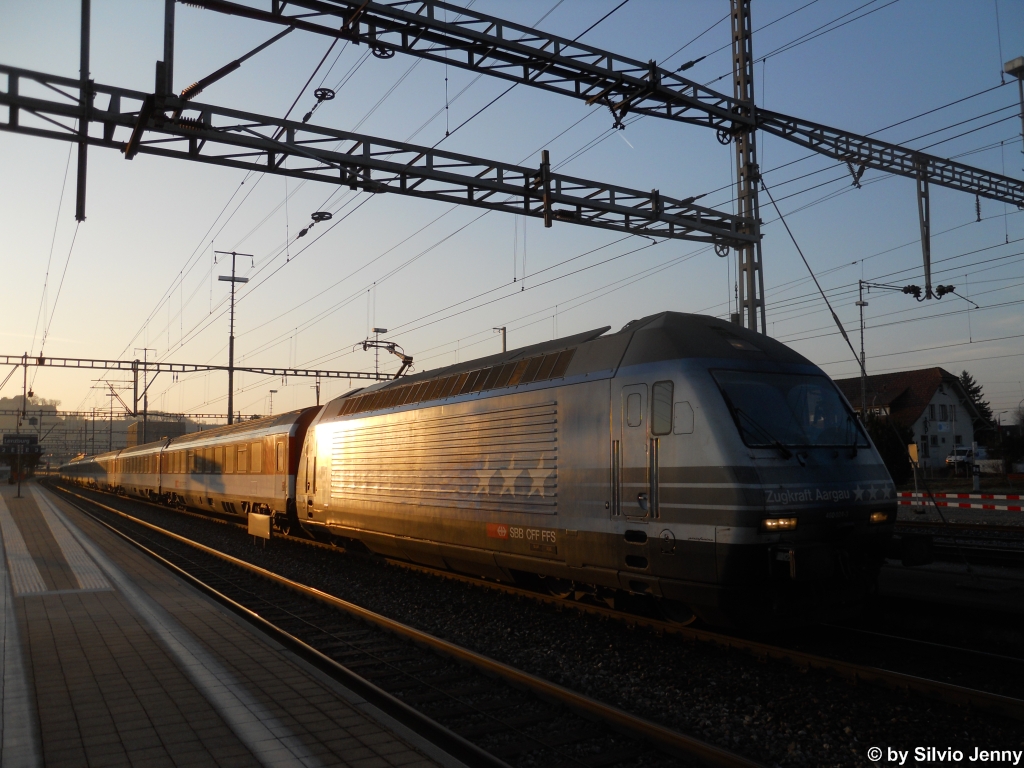 Die ersten Sonnenstrahlen begrssen am 17.3.2012 in Lenzburg die Re 460 024-3 ''Zugkraft Aargau'' mit dem Auto-Salon-Extrazug 30510 nach Genf.