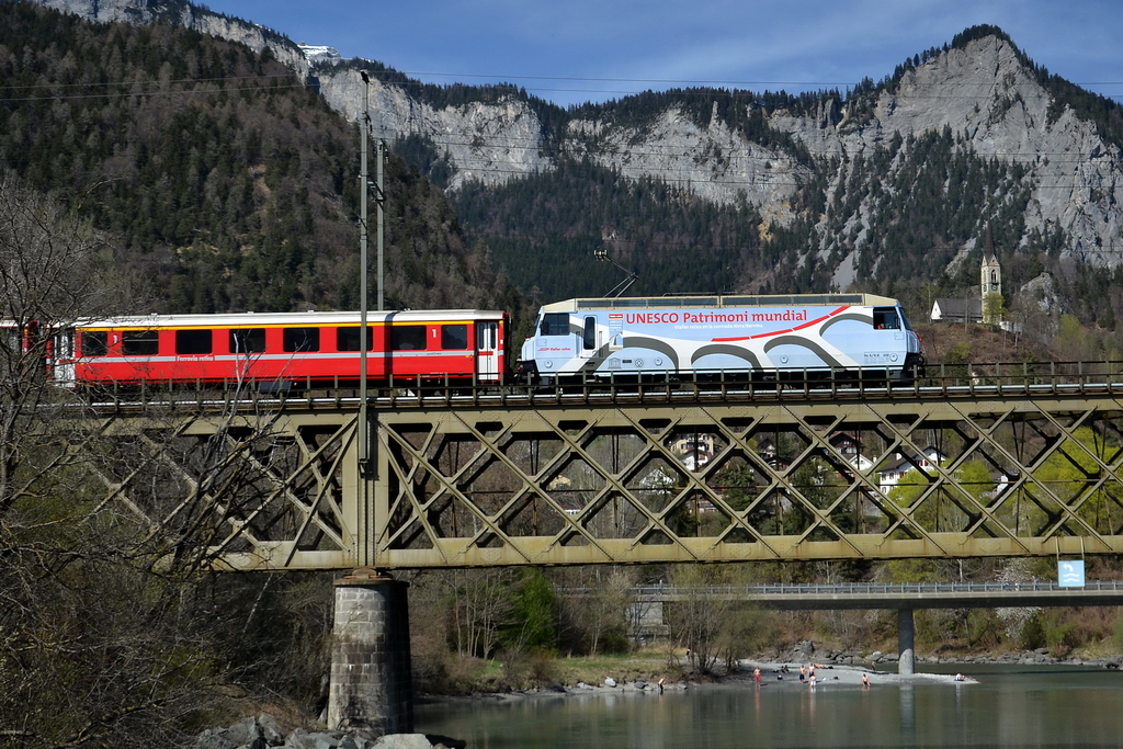 Die Ge 4/4 III 650   Unesco   mit einem Regionalzug auf der Eisenbahnbrcke bei Reichenau-Tamins. Unten tummeln sich schon die ersten Leute im sehr kalten Rheinwasser. Sonntag, der 3.4.2011.