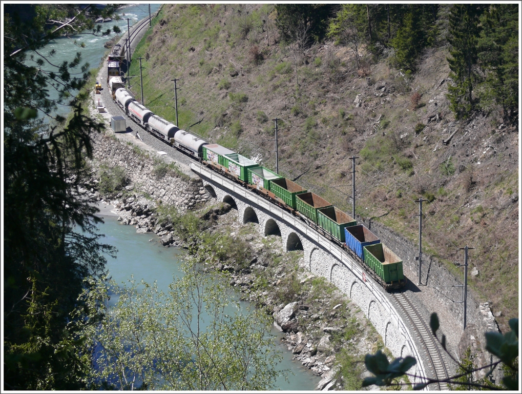Die Ge 6/6 II 702  Curia  zieht einen langen Gterzug Richtung Disentis. Diesen Sommer wird hier der durchgehende Wanderweg zwischen Trin Station und Reichenau-Tamins gebaut. Die Hngebrcke ber den Vorderrhein bei der Station Trin ist bereits im Bau, sodass man neu auf die Bonaduzer Seite wechseln kann, was fr Bahnfreunde unzhlige neue Fotostandpunkte erschliessen wird. (28.04.2010)