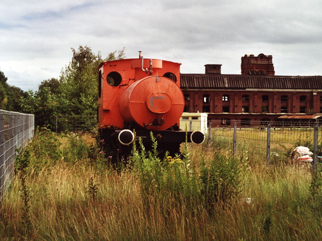 Die gleiche Feuerlose Lok in drei verschiedene Lackierungen auf zwei verschiedene Platzen in Gronau (Westfalen). Die Feuerlose Lok “Baumwollspinnerei 1” (Borsig, Fabriksnummer 7595, Baujahr 1910) der Eisenbahnfreunde Gronau als Denkmal auf dem Gelnde der ehemaligen Textilfabrik van Delden in Gronau am 25-6-2000. Bild und scan: Date Jan de Vries.