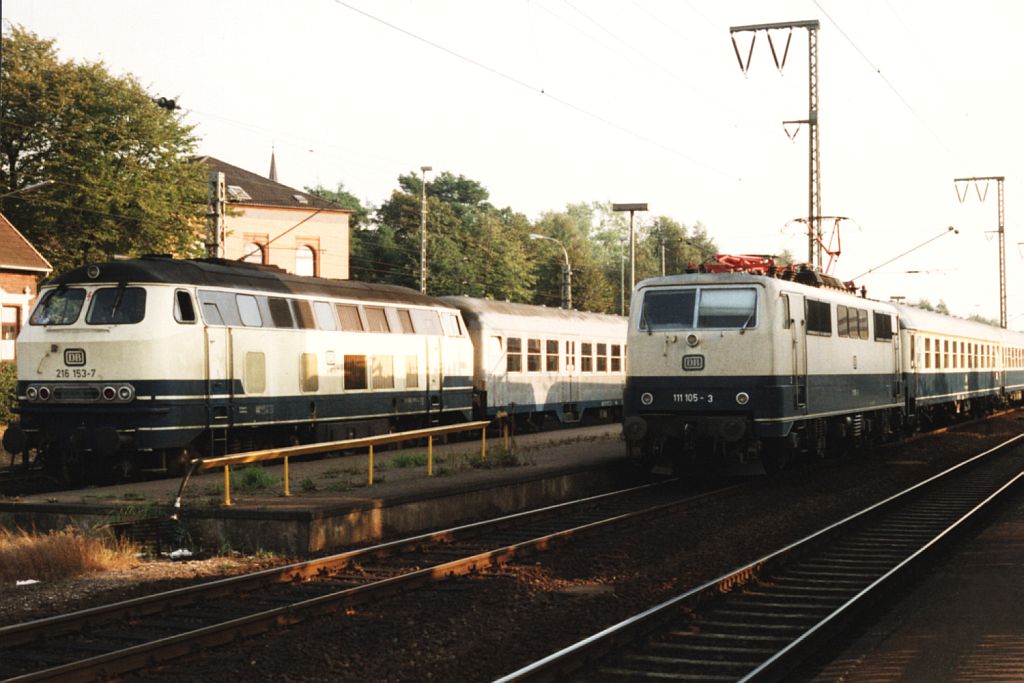 Die gute alte Zeit mit ozeanblaubeige Loks und Dieselz�ge zwischen Oldenburg und Leer. Die 111 105-3 mit einem Eilzug Rheine-Emden neben die 216 153-7 mit einem Eilzug zwischen Leer und Oldenburg auf Bahnhof Leer am 14-9-1991. Bild und scan: Date Jan de Vries.