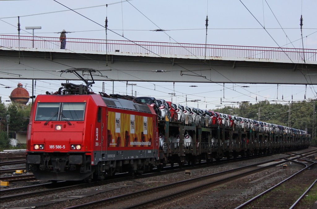 Die HGK 2054 (185 586)  Heizprofis  am 1.9.11 mit einem Ford Autozug bei der Durchfahrt durch Duisburg-Entenfang.