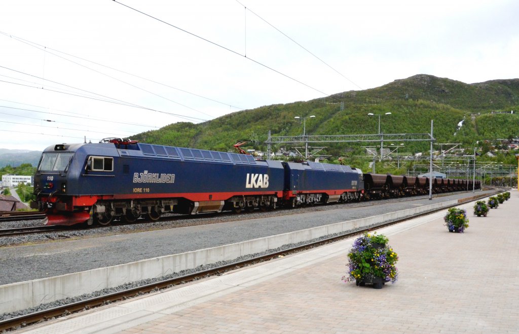 Die IORE BJRLIDEN 110 und KAITUM 124 Lokomotiven/Doppelloks (10.800 kW) und jeder der Wagen fasst bei gleichem Leergewicht 100 Tonnen Erz. Aus 68 Wagen lsst sich somit ein 700 Meter langer und 6860 Tonnen schwerer Zug bilden, der beladen mit 60 km/h und leer mit 70 km/h verkehren kann. Narvik am 26.06.2012.


