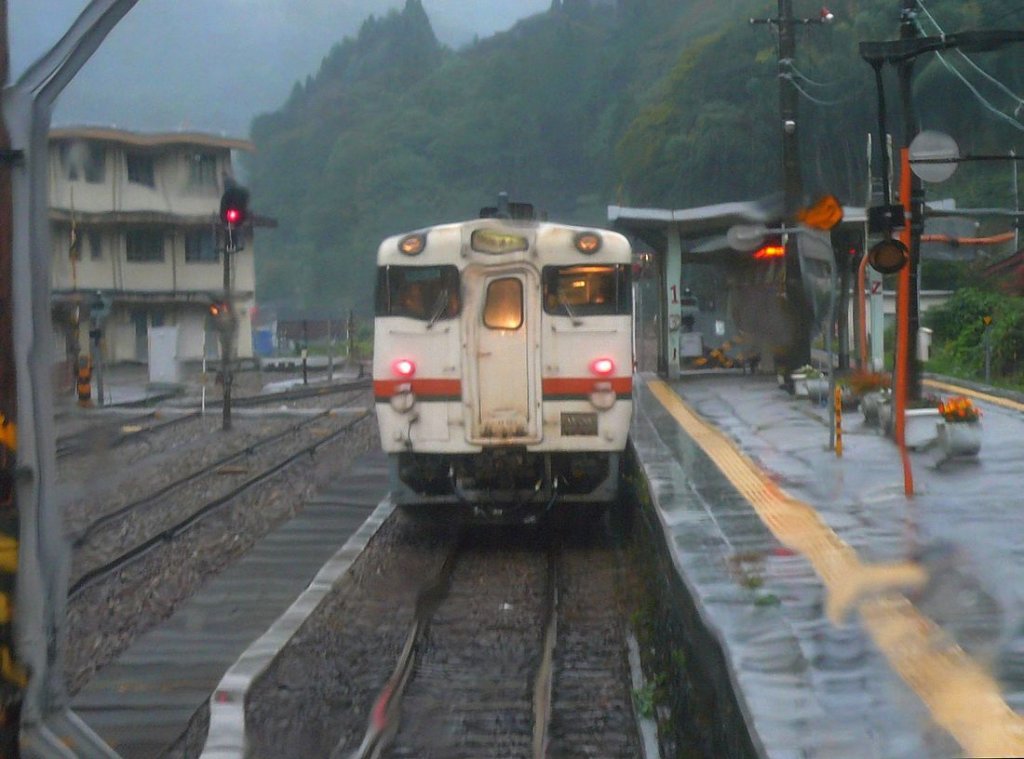 Die KIHA 48 der Takayama Linie - an der Gebietsgrenze JR Central/JR West:
Ein betrunkener KIHA 48? Von Norden kommend nähert sich der kleine JR West-Triebwagen dem Grenzpunkt; hier müssen sie - trotz sintflutartigem Regensturm - in den KIHA 48 6812 der JR Central umsteigen. Bild aus dem JR West-Triebwagen KIHA 120 344, 2. Oktober 2009.