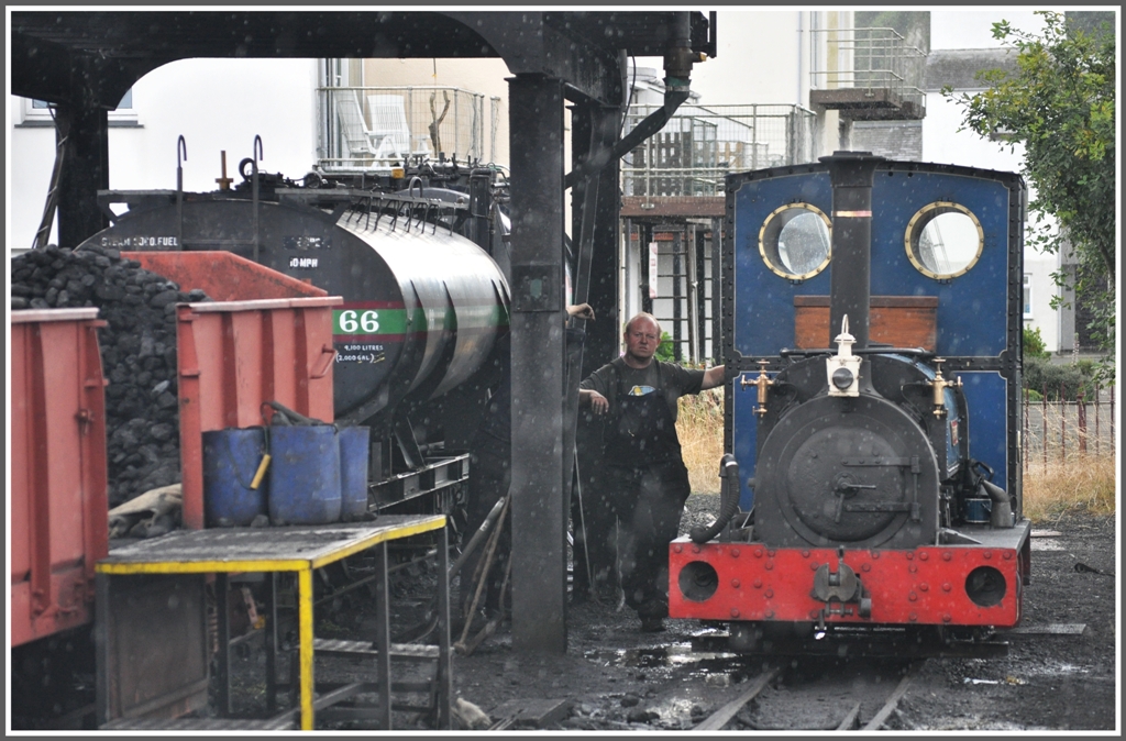 Die kleine Britomart von Hunslet Engines & Co an der  Tankstelle  in Porthmadog. Mit einem krftigen Regenschauer muss in Wales immer gerechnet werden, so auch genau in diesem Moment. (14.08.2011)