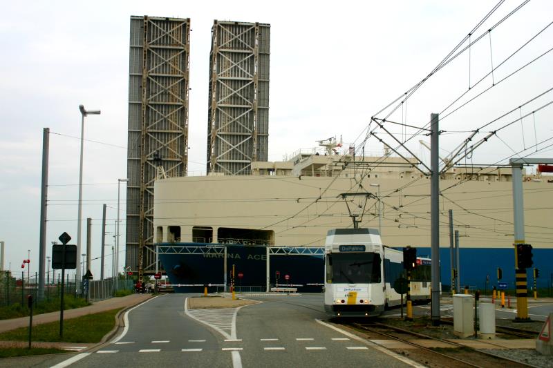 Die Kusttram ist ansich schon ein geniales Verkehrsmittel. Genialer ist die Linienf�hrung zwischen den Stationen Zeebrugge-Zeeluis und Heist-Dijk. Wenn ein Schiff den Hafen verl�sst und durch den Zeeluis geschleppt wird, ist immer eine Br�cke geschlossen und eine ge�ffnet. W�hrend die M/S  Marina Ace  die ge�ffnete Klappbr�cke der Kustlaan passiert, machte die Kusttram auf dem Weg von Knokke nach De Panne nun einen kurzen Umweg �ber die Isabellalaan und Zeeluisstraat um hinter dem Schiff den Zeeluis zu �berqueren. Zeebrugge, 13.05.2005