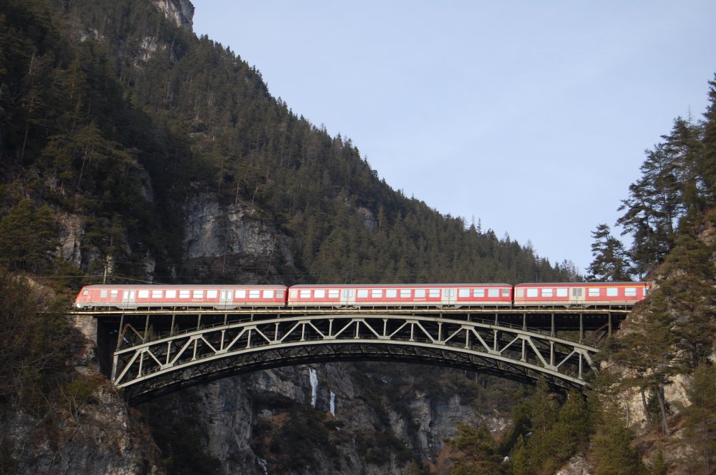 Die letzen drei Wagen des Regionalzuges Mnchen Hbf -Innsbruck Hbf berfahren am 24.1.2010 die Schlobach-Brcke, whrend die 111 und die ersten Wagen schon im gleichnamigen Tunnel (721,52 m) verschwunden sind. 