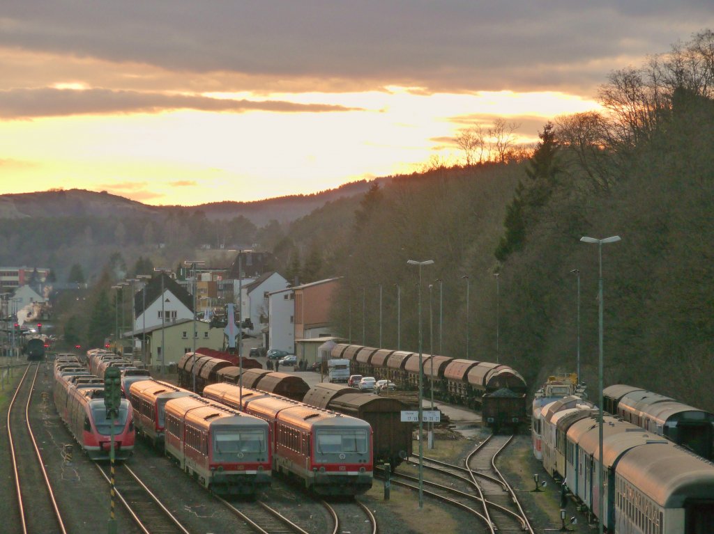 Die letzten Sonnenstrahlen werfen ihr Licht auf eine Reihe im Bahnhof Gerolstein abgestellter Triebwagen der BR 628.