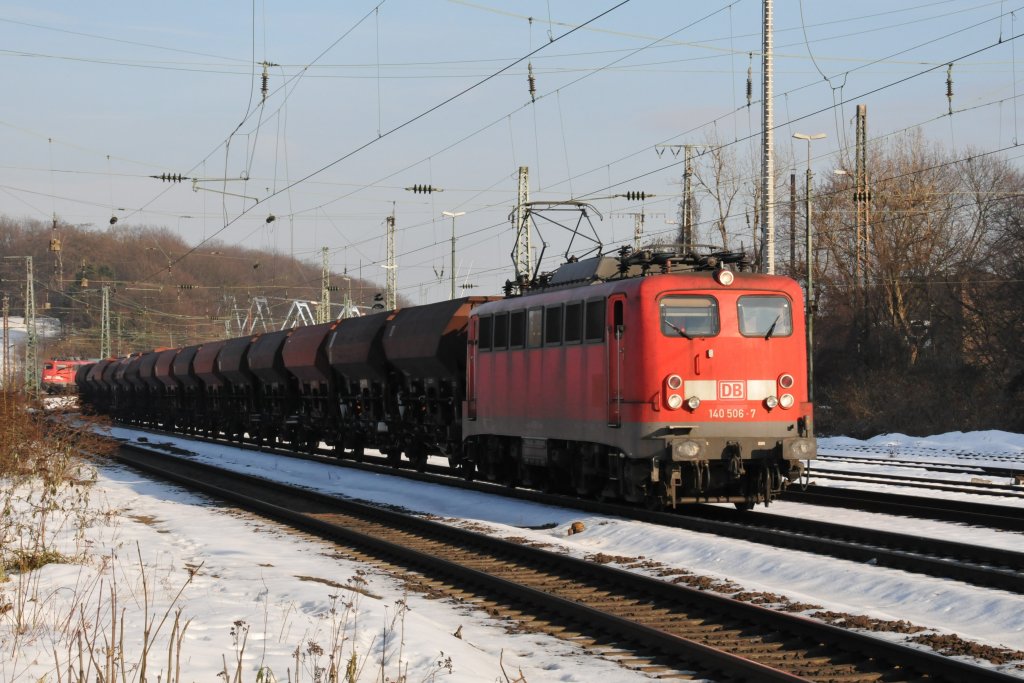 Die mit einem zustzlichen Scheinwerferpaar versehene 140 506-7 zieht einen langen Gterzug durch Kln-West. Hinten links erkennt man schon die 110 454-6, die mit ihrem IC das nchste interessante Fotomotiv darstellt. Aufgenommen am 04/01/2011.