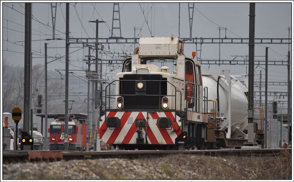 Die normalspurige Em 837 954-7 rangiert einen schmlaspurigen Containertragwagen in Unterva-Trimmis. (08.04.2013)