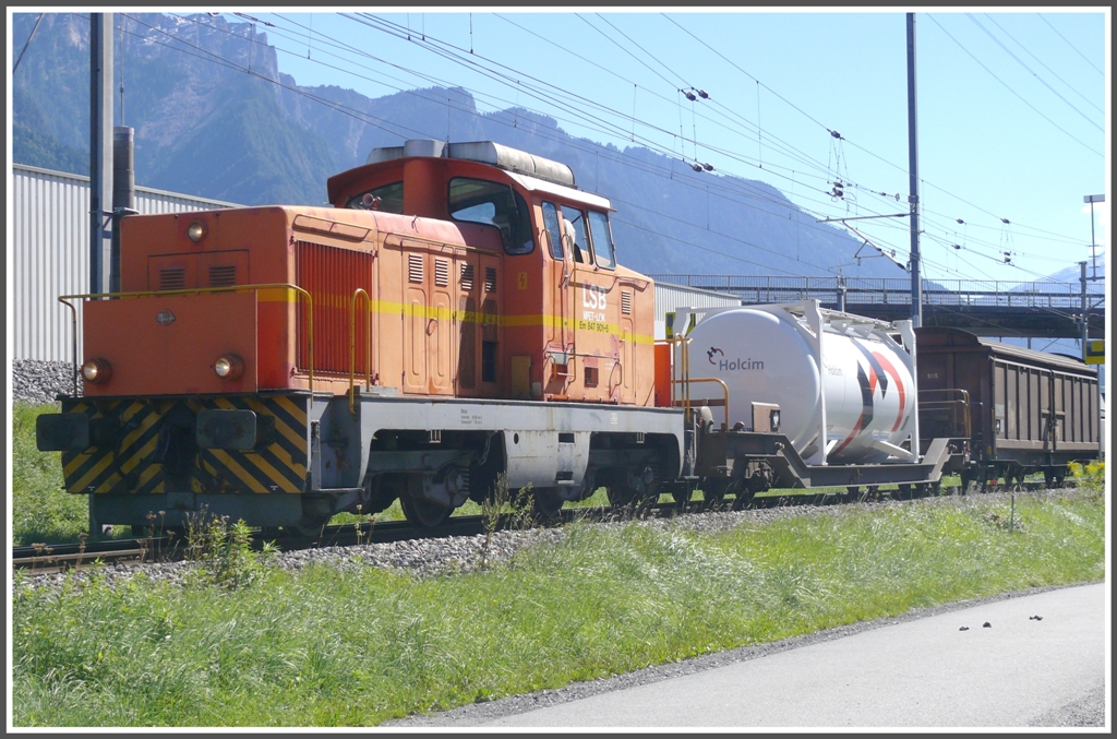 Die normalspurige Mietlok LSB Em 847 901-6 bringt zwei schmalspurige RhB Wagen ber das Dreischienengleis aus dem Holcimwerk. (01.09.2010)