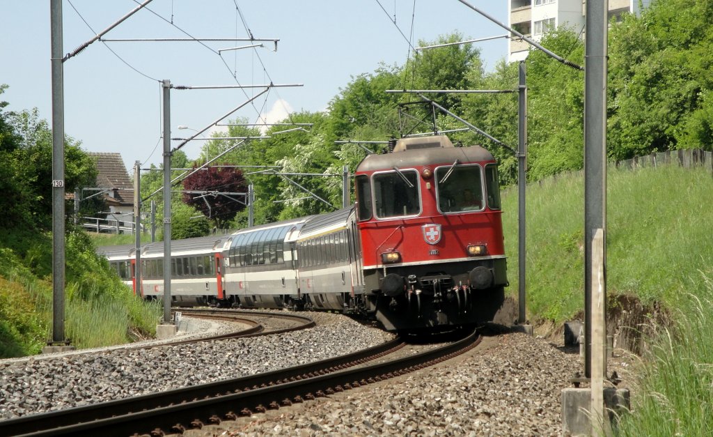 Die Re 4/4  11112 befindet sich am 02.05.11 mit einem IR nach Locarno in der 180-Kurve im Raum Rothenburg.