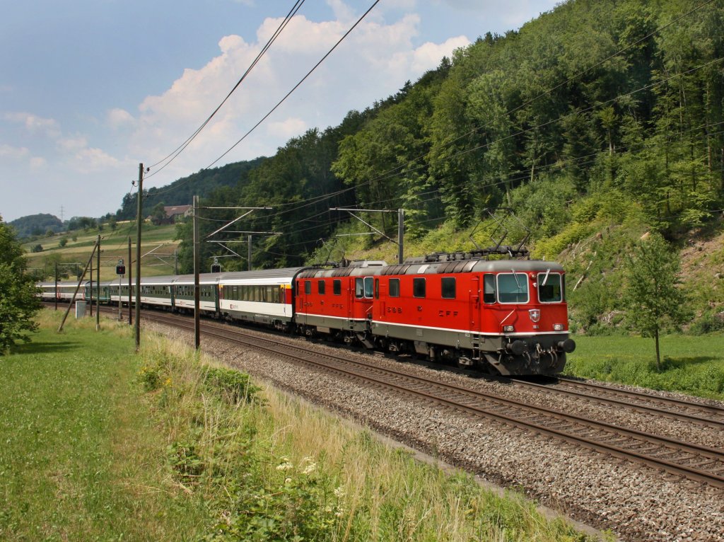 Die Re 4/4 11135 und einer Weiteren mit einem IR am 28.06.2011 unterwegs bei Tecknau. 