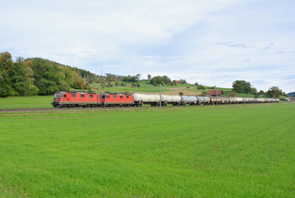Die Re 4/4 II 11242 und die 11188 ziehen einen Kesselwagenzug bei Elgg in Richtung WInterthur, 17.10.2012.