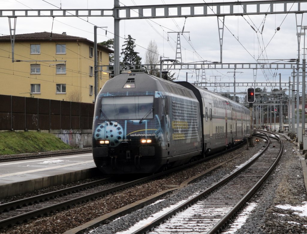Die Re 460 080-5 mit der Werbung fr das Verkehrshaus durchfhrt am 07.12.10 den Bahnhof Morges mit einem IC am Haken.