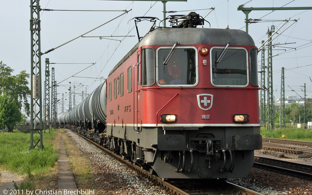 Die Re 6/6 11617 mit einem schier Endlosen Tankwagenzug beim Warten auf die freie Fahrt ber den Rhein, da jetzt eine neue Eisenbahn Brcke gebaut wird am 28.04.2011 beim Bad Bhf Basel.