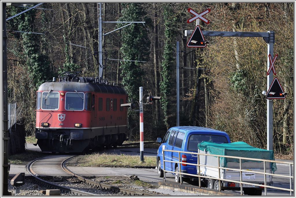 Die Re 6/6 11640  Mnchenstein  entschwindet durch eine scharfe Rechtskurve beim Bahnhof Hntwangen-Wil in den Wald Richtung Kiesverladeanlage. (08.03.2013)