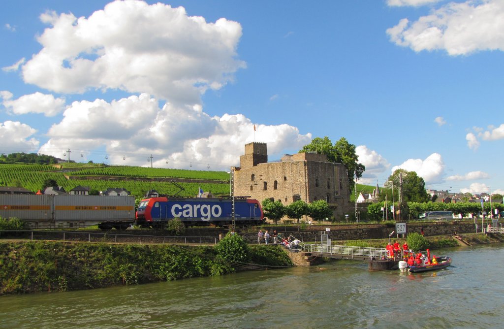 Die rechte Rheinstrecke fhrt in Rdesheim zwischen Rhein und der B42 mitten durch den beliebten Touristenort. Im Hintergrund erkennt man die Brmserburg und die Seilbahn zum Niederwalddenkmal; 07.07.2012