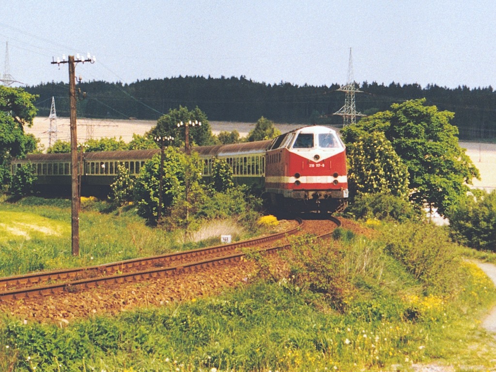 Die Regionalbahn mit 219 117 an der Spitze wurde am 18.5.98 am nrdlichen Ortsrand von Remptendorf fotografiert.
