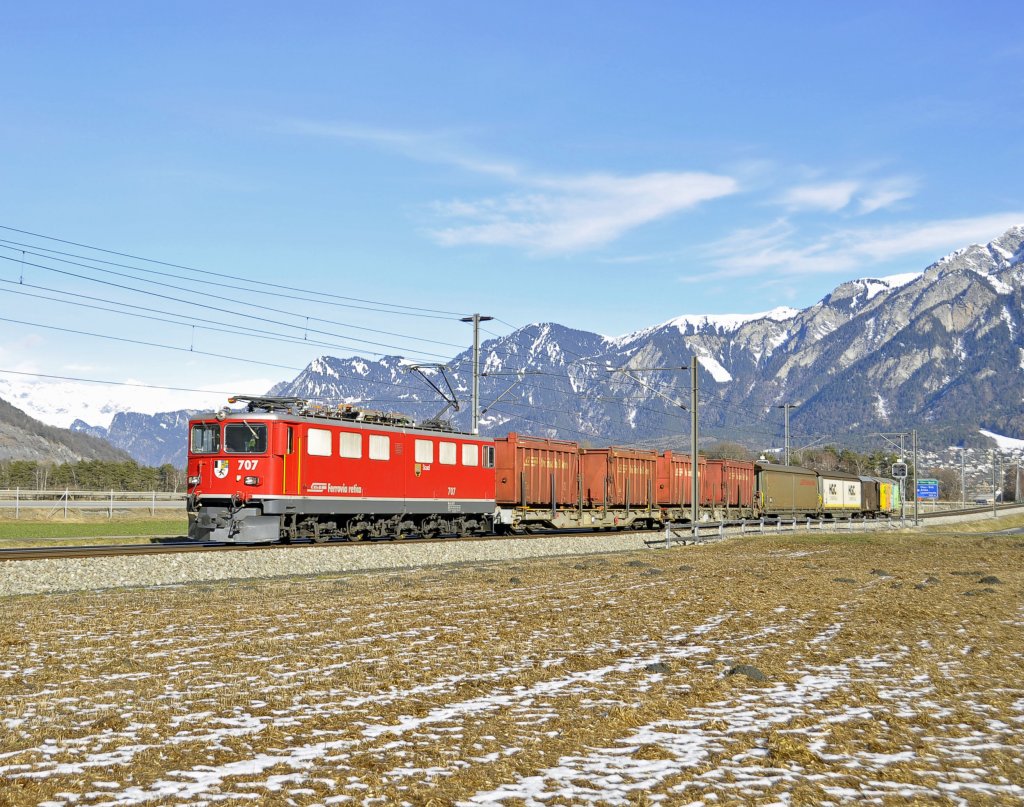 Die RhB Lokomotive 707 mit dem Namen Scuol vom Typ Ge 6'6 II ist mit einem fr die Rhtische Bahn typischen Gterzug Richtung Domat-Ems unterwegs.Bild entstand bei herrlichem Wetter am 30.1.2013 bei Felsberg.