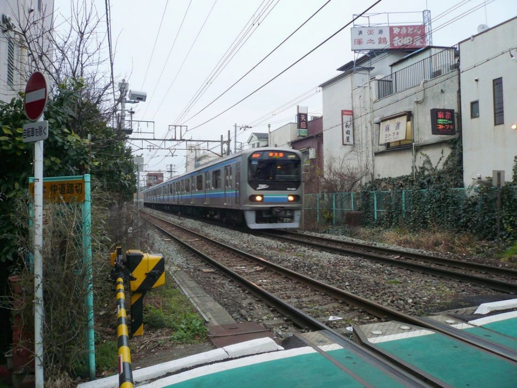 Die Rinkai-Linie: An einem sehr dsteren Tag nhert sich Zug Nr.2 (mit Frontwagen 70-020) einer kleinen Mahjong-Spielbude in einem alten Teil von Tokyo. Zwischen Akabane und Jj, 27.Februar 2010. 