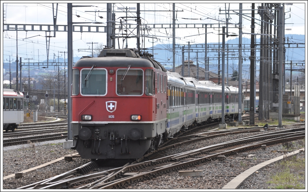 Die SBB Re 4/4 II 11135 schiebt den IR 2422 VAE aus dem Bahnhof Romanshorn. (30.03.2011)