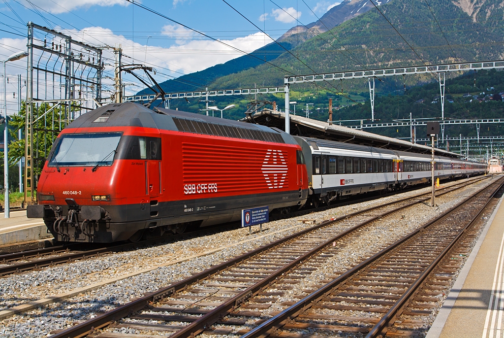 Die SBB Re 460 048-2  Zri Wyland  steht mit einem IC am 28.05.2012 im Bahnhof Brig.

Der Taufname der Lok  Zri Wyland  zu deutsch Zrcher Weinland.