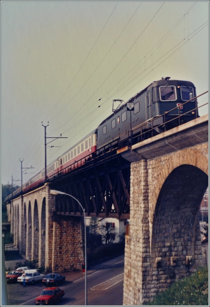 Die SBB Re 6/6 11645  Colombier   ist mit dem IC  Mont-Blanc  375 von Genève nach Hamburg Altona auf dem BLS/MLB Mössliviadukt in Grenchen unterwegs.

Analogbild vom März 1985