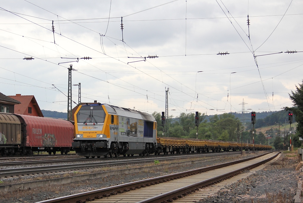 Die SGL Maxima V500.14 alias 264 009-2 mit Altschotter auf Flachwagen in Richtung Bebra. Aufgenommen am 15.07.2011 in Mecklar.