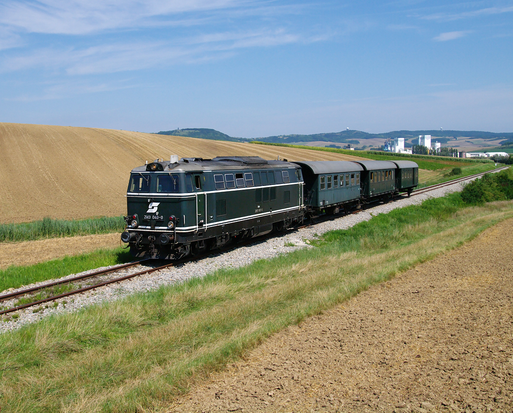 Die SGP Diesellok 2143 040 war am 05.08. als EZ  Leiserberge  im Weinviertel unterwegs. Dieses Bild zeigt den Erlebniszug bei der mitt�glichen Zwischenfahrt von Ernsbtunn nach Korneuburg, aufgenommen bei Gebmanns.